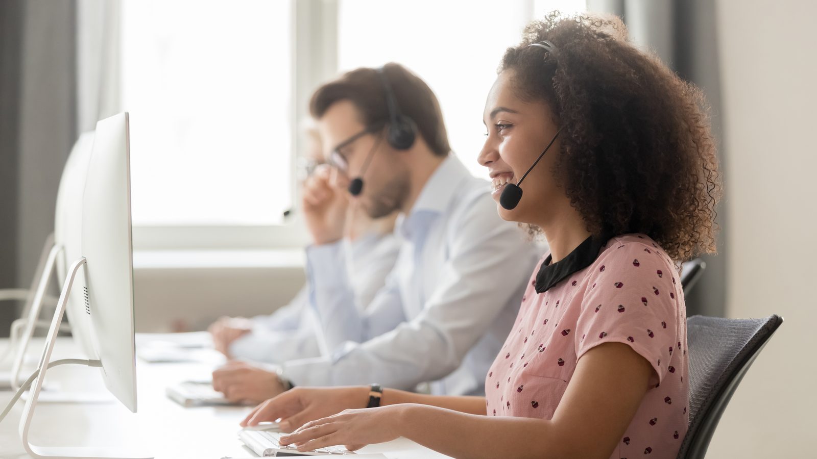 Kundenberatung der BIG am Telefon: eine Beraterin und ein Berater mit Headset