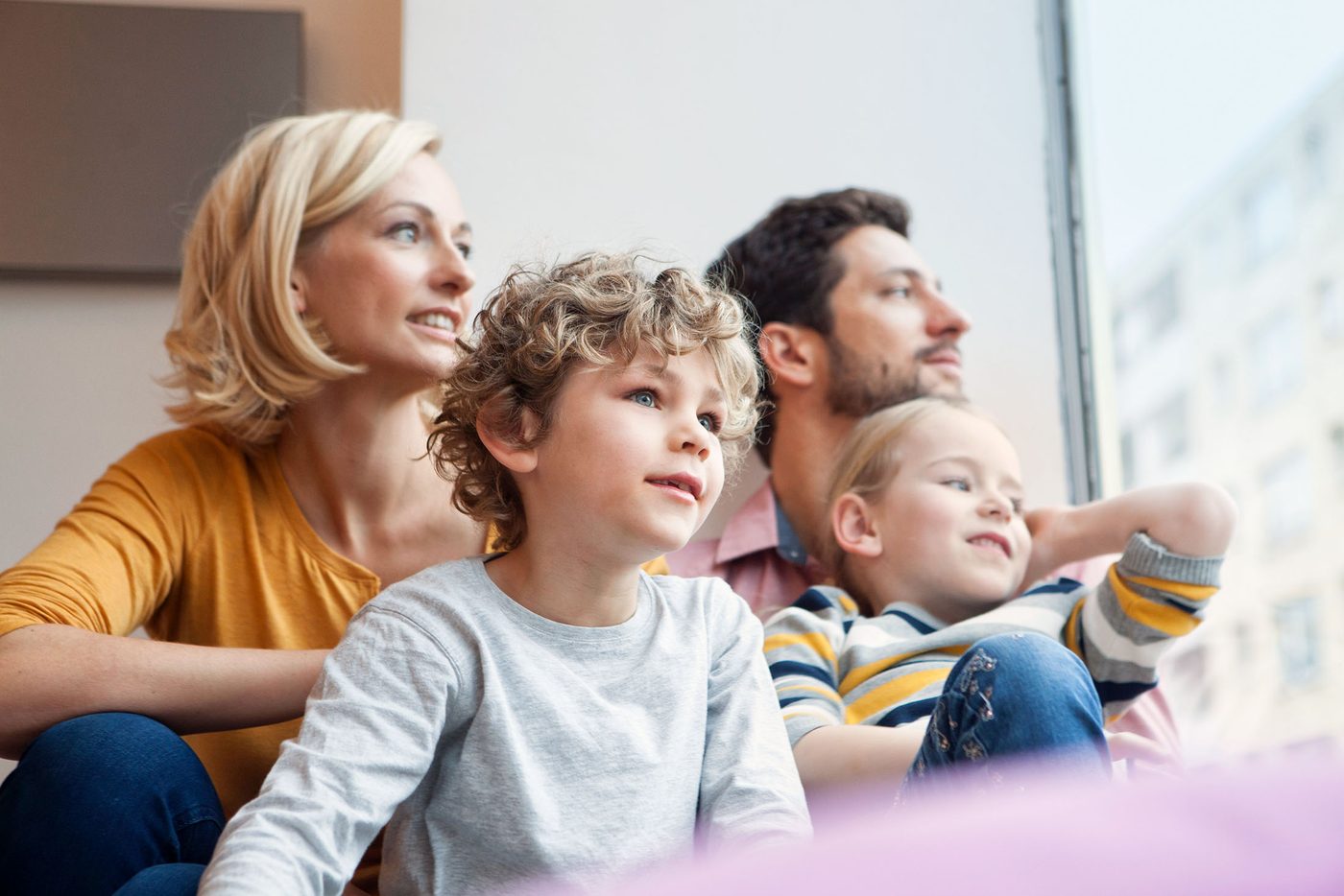 Eine Familie schaut gemeinsam aus dem Fenster