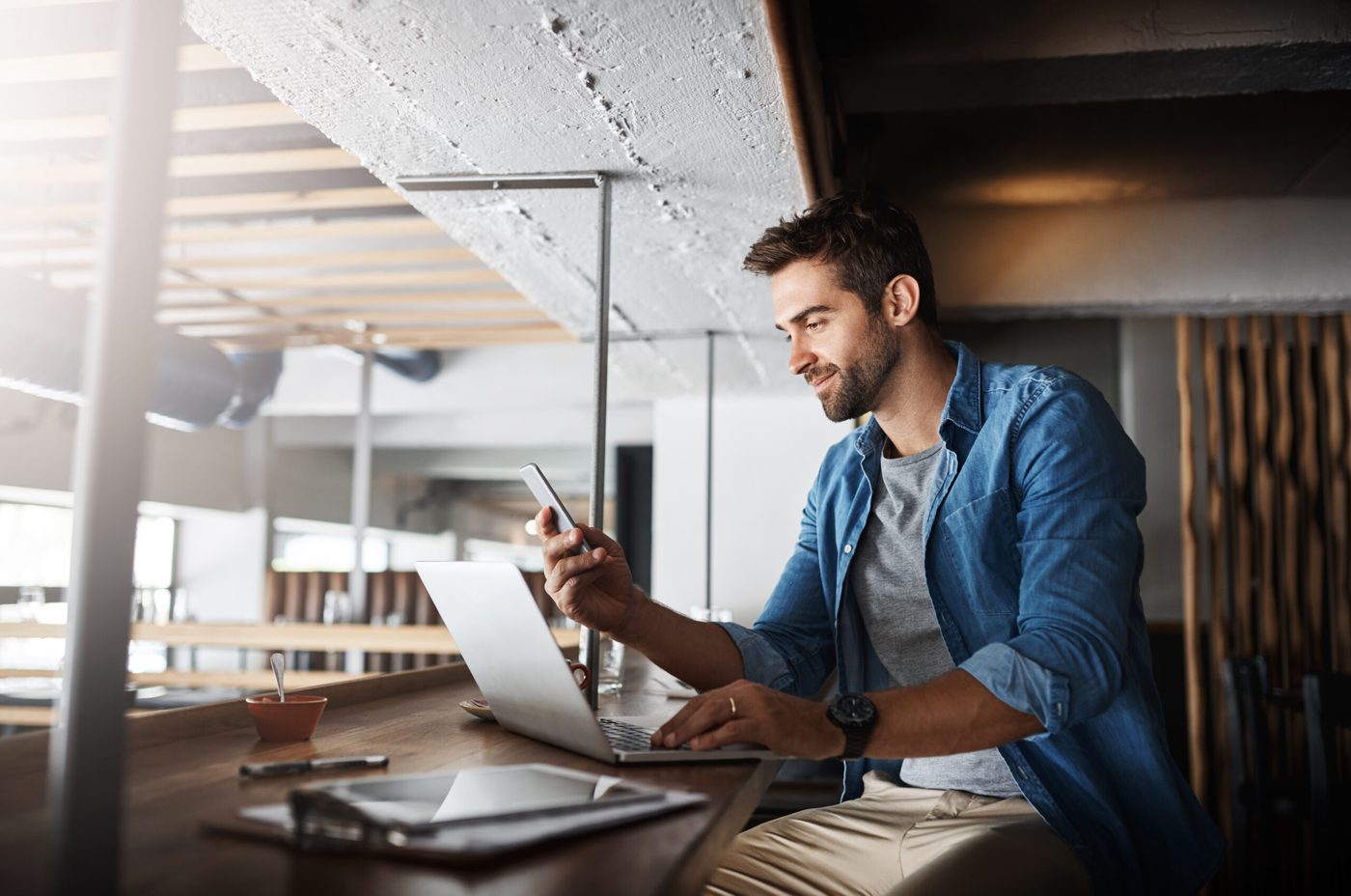 Ein Mann telefoniert am Schreibtisch mit Laptop